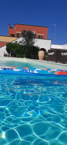 a swimming pool with blue water in front of a house at Villa Matine in Specchia