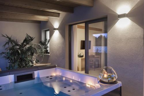 a bathroom with a large tub with a mirror at Ros'e Mari Green Home Hotel in Oristano