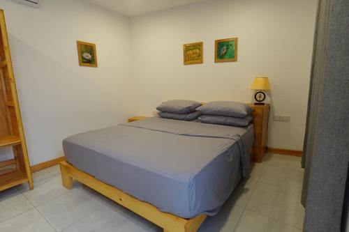 a bedroom with a bed with two pillows on it at Stay Kora in Thinadhoo