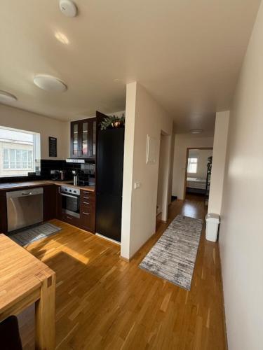 a kitchen with a black refrigerator and a wooden floor at Norðurgata 43 in Akureyri