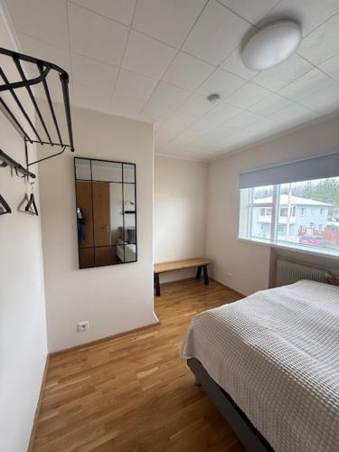 a bedroom with a bed and a mirror on the wall at Norðurgata 43 in Akureyri