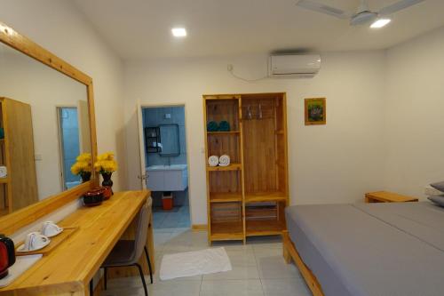 a bedroom with a bed and a desk and a sink at Stay Kora in Thinadhoo