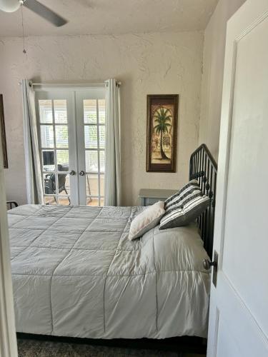 a bedroom with a large white bed with pillows on it at Historic Home near the water - perfectly walkable spot! in Lake Worth
