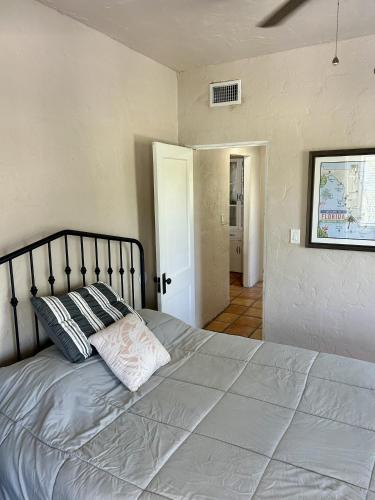 a bedroom with a large bed with two pillows at Historic Home near the water - perfectly walkable spot! in Lake Worth