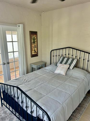 a bedroom with a large bed with a metal frame at Historic Home near the water - perfectly walkable spot! in Lake Worth