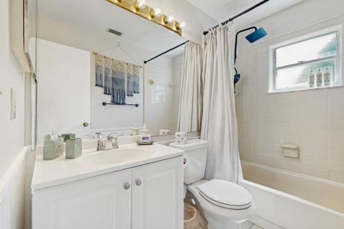 Un baño blanco con lavabo e inodoro. en The Boho Bungalow, en Orlando