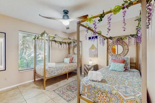 Un dormitorio con dos camas y un ventilador de techo. en The Boho Bungalow, en Orlando