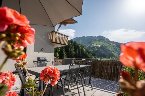 a patio with a table and chairs and flowers at Appartements MaLo by we rent in Viehhofen