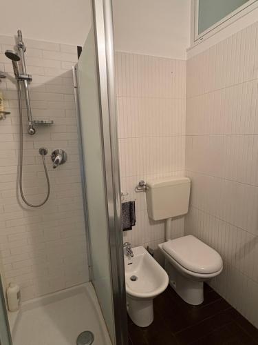 a bathroom with a toilet and a sink and a shower at Cozy Green Apartment Tardini, Parma in Parma