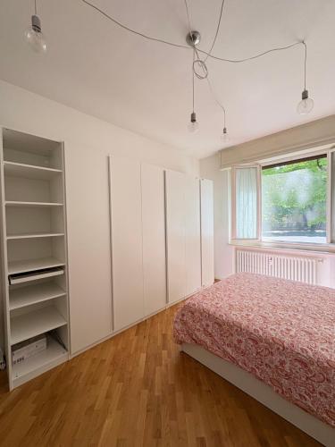 a bedroom with a bed and a window at Cozy Green Apartment Tardini, Parma in Parma