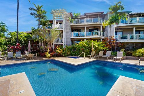 a swimming pool in front of a building at Wailea Grand Champions 7 in Wailea