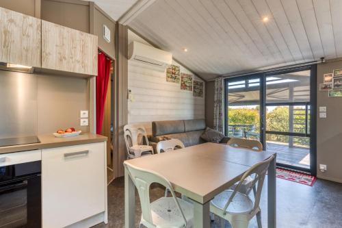 a kitchen and dining room with a table and chairs at Chalet de la Grenatière in Pomérols