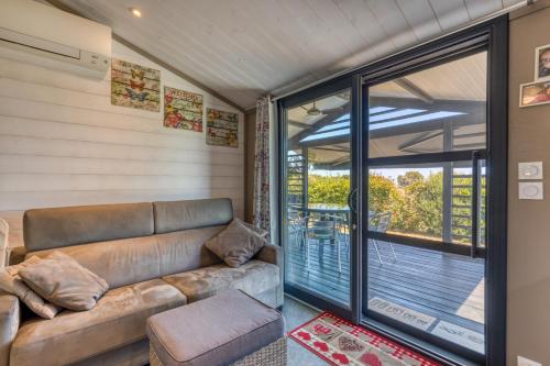 a living room with a couch and a sliding glass door at Chalet de la Grenatière in Pomérols