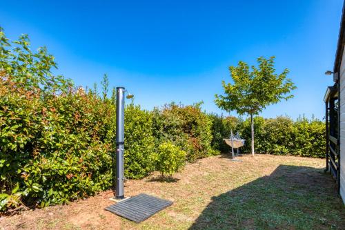 a garden with a grill and some bushes at Chalet de la Grenatière in Pomérols