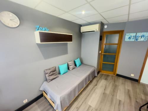 a bed in a room with a clock on the wall at Le Mirevalais-Entre Montpellier et Sète-Clim & parking privé in Mireval