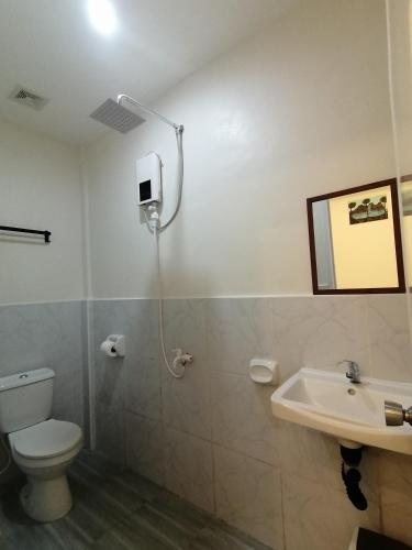 a bathroom with a toilet and a sink at Malunggay's Inn in Panglao Island