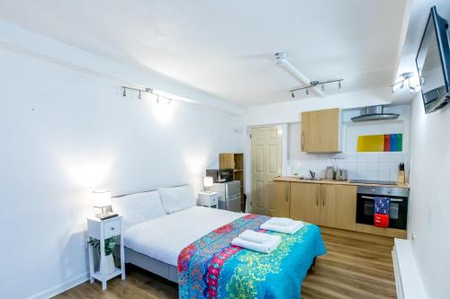 a small bedroom with a bed and a kitchen at Glastonbury - ContactlessCheckIn - Free Parking in Glastonbury
