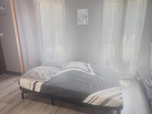 a bed sitting in a room with a window at Le Mirevalais-Entre Montpellier et Sète-Clim & parking privé in Mireval