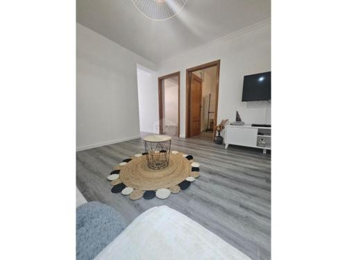 a living room with a table and a tv at Cris Place in Câmara de Lobos