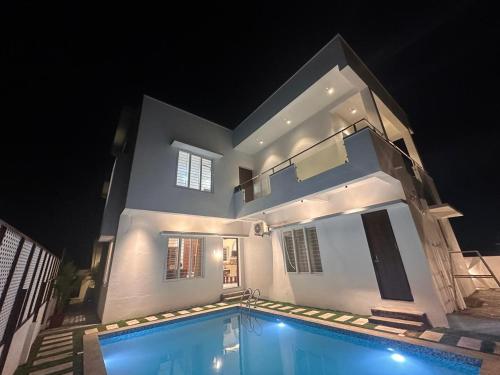 a house with a swimming pool in front of it at night at Extasea Beach Villa in Cheyūr