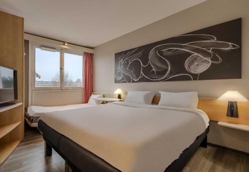 a hotel room with a large bed and a tv at B&B HOTEL Boulogne-sur-Mer Centre Les Ports in Boulogne-sur-Mer