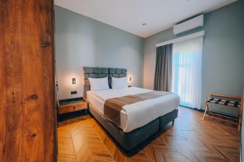 a bedroom with a large bed and a large window at The Green Park Sapanca in Sapanca