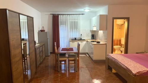 a room with a kitchen and a table and a bed at Apartman Mario in Umag