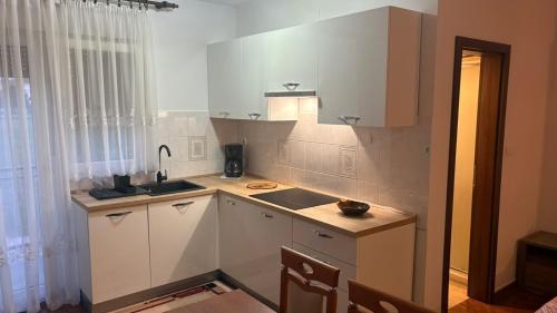 a kitchen with white cabinets and a sink at Apartman Mario in Umag
