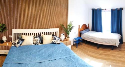 a bedroom with a bed with blue sheets and pillows at Casa MACON BLUE in Caleta De Fuste