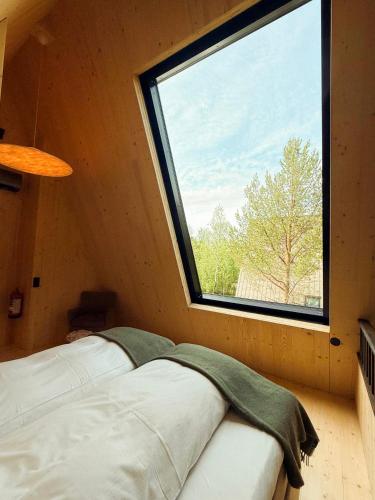a bed in a room with a large window at Holmen Husky Lodge in Alta