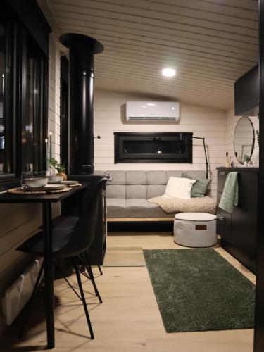 Una sala de estar con un sofá y una estufa. en Little Aurora Cabin, en Rovaniemi