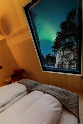 a bedroom with a window with a view of the northern lights at Holmen Husky Lodge in Alta