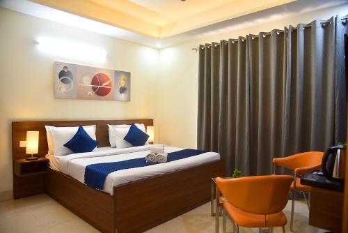 a bedroom with a bed with blue pillows at Luxury Studio Apartment with Kitchenette & Private Balcony ,Gurugram in Gurgaon