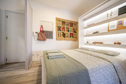 a bedroom with a large bed with a blue blanket at Like Home - Estúdio do Rio in Paço de Arcos