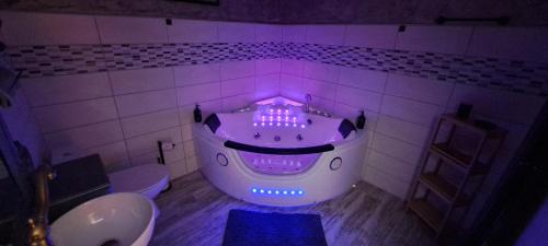 a bathroom with a tub with purple lights in it at Insinuances in Douzens