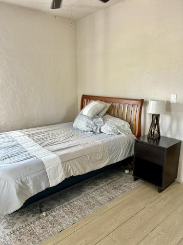 a bedroom with a bed and a nightstand with a lamp at Historic Home near the water - perfectly walkable spot! in Lake Worth