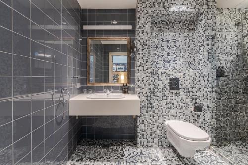 a bathroom with a sink and a toilet at Eurostars Metropole in Rīga