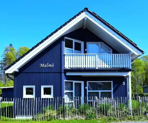 a blue house with a balcony and a fence at Malmö in Brasilien