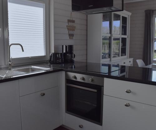 a kitchen with black counter tops and a sink at Malmö in Brasilien