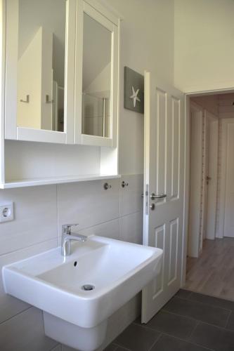 a bathroom with a white sink and a mirror at Malmö in Brasilien