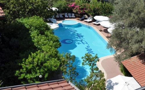 an overhead view of a swimming pool with umbrellas and trees at Mr. Dim Exclusive Apart Hotel in Göcek