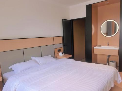 a bedroom with a large white bed and a sink at Yushe Shiguang Xiaozhu in Jining