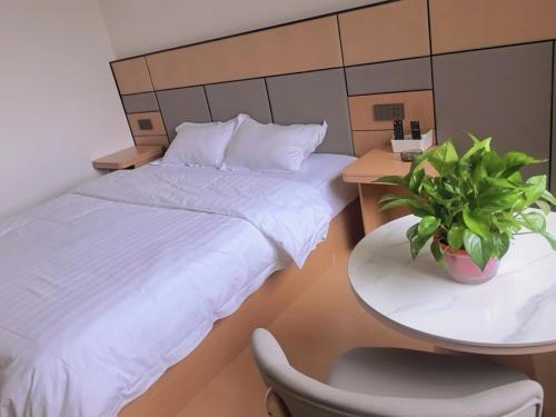 a bedroom with a bed and a table with a plant at Yushe Shiguang Xiaozhu in Jining