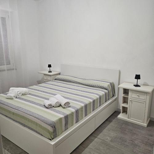 une chambre blanche avec un lit avec des serviettes dessus dans l'établissement Via Genova, à La Caletta