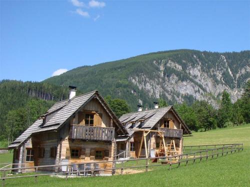 a log cabin in a field with a mountain at Feriendorf Lassing-Hochkar in Göstling an der Ybbs