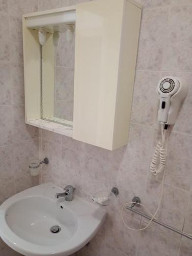 a bathroom with a sink and a phone on the wall at Hotel Lungomare Brancaleone in Brancaleone Marina