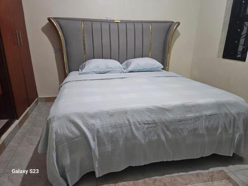 a bed with a silver blanket and pillows on it at Spea Residency Apartment in Mbarara