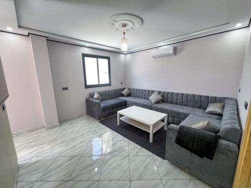 a living room with a couch and a table at Appartement Alhoceima in Imejoudene