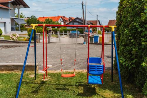 a playground with swings in a yard at Kuća za odmor Dugo Selo M&A in Dugo Selo