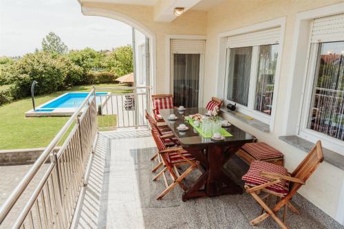 a porch with a table and chairs and a pool at Kuća za odmor Dugo Selo M&A in Dugo Selo